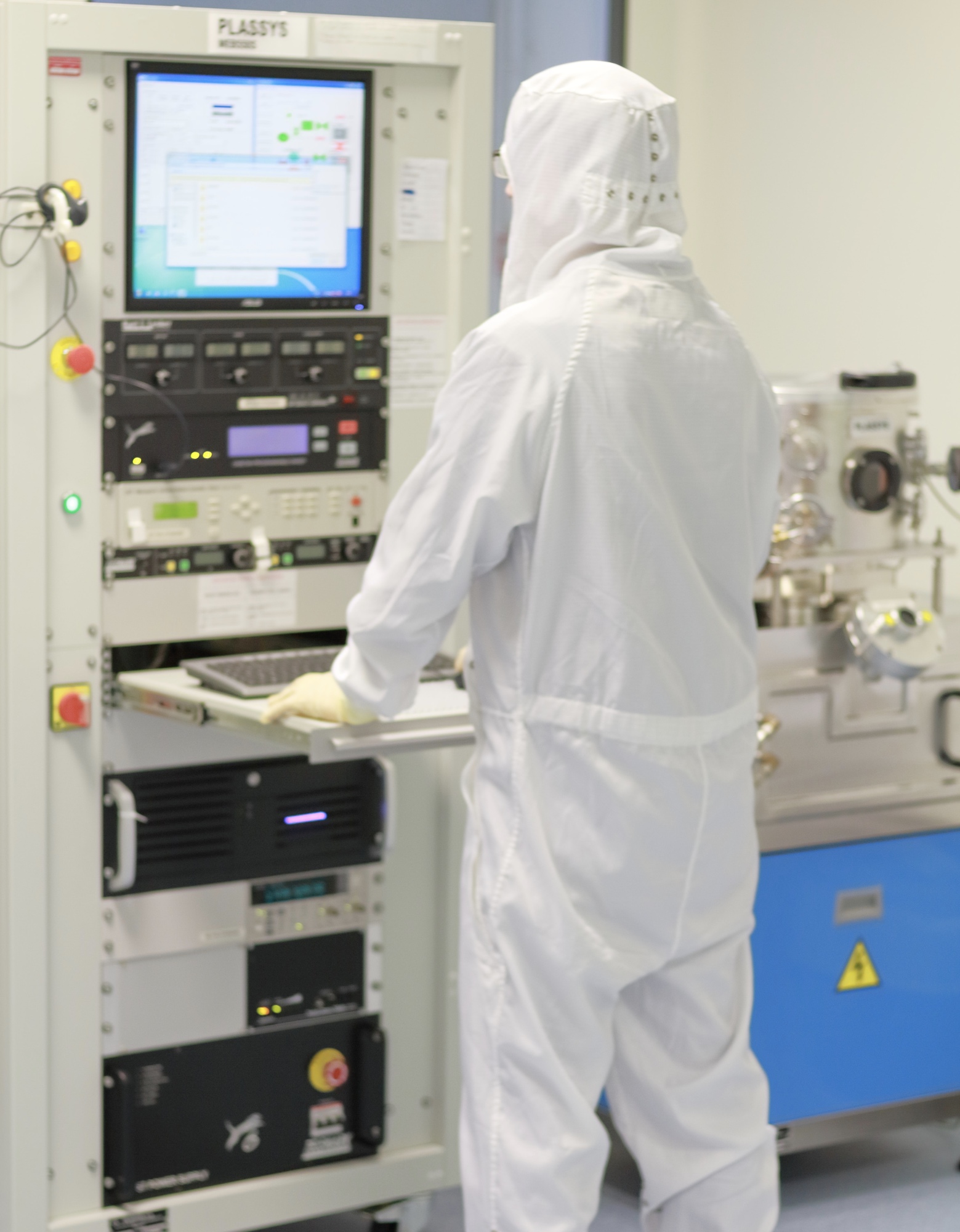 Cleanroom operator standing at an terminal.